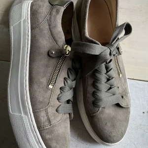 Olivgröna sneakers stl 38 - Läckra sneakers från Gabor i mycket bra skick. Snygg dragkedja och bakkappa i metallicskinn som extra  accent.  Olivgrön mocca passar till allt. 