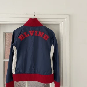 Jacka elvine! - En tunn jacka från elvine! Storlek medium med sitter mer som en S! Jackan är i gott skick men har använts. Det röda är lite nopprigt och jackan är smått sliten!⚡️
