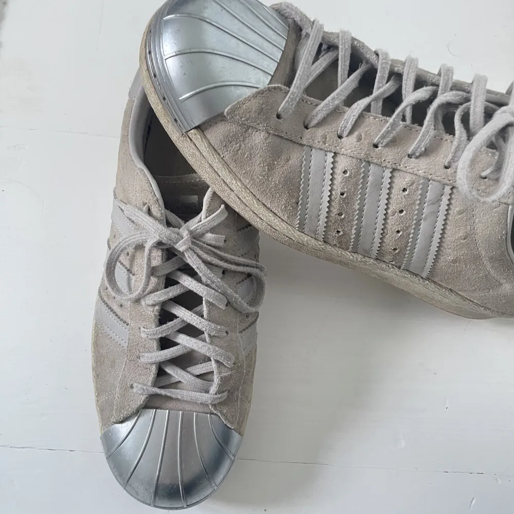 Säljer ett par adidas skor i grå färg. Väldigt fint skick och har en metall bit längst fram på skorn! . Skor.