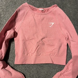 Gymshark topp - Långärmad croppad träningstopp från gymshark i storleken XS. Aldrig använd, endast testad och är därför i perfekt skick. Kan strykas innan den skickas om det önskas.