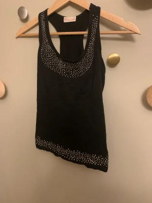 Y2k fest topp - Säljer denna snygga fest topp i y2k stil med nitar på, har endast andvändt den ett fåtal gånger, den är i st xs men sitter som en s ❤️