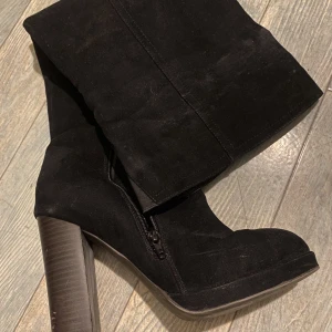 Knähöga boots - Knähöga boots i mocka. Några repor på klacken. Klackhöjd ca 10cm.