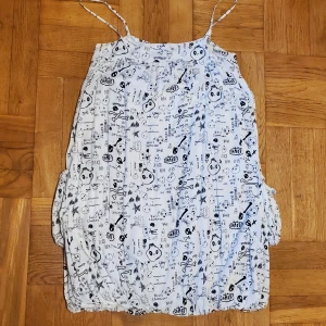 Ballongklänning med dödskallar - Ballongklänning MED FICKOR, tryck och text från Saints & Mortals. I gott skick förutom att axelbandens spännen gått sönder och därför är ojusterbara. Storlek S men stretchig och kan passa M-L också. Okej att komma med bud. Katt i hemmet. Skärp ingår ej.