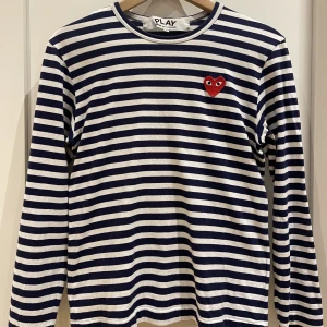 CDG tröja - Väldigt snygg blå-vitrandig Comme des Garçons PLAY tröja i väldigt bra skick. Köpt på Paul & Friends i Stockholm. Nypris ca. 1500kr