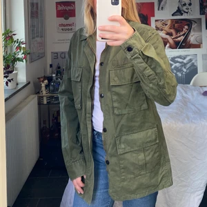 Militärgrön jacka - En militärgrön jacka med flera fickor