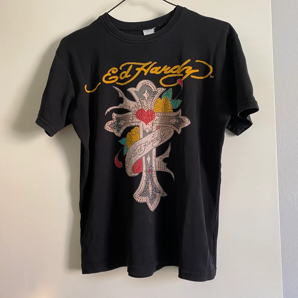 (Lägger ut igen pga oseriös köpare) Säljer denna coola Ed Hardy t-shirt. ❤️Det är några paljetter som lossnat på korset. Se bilder. Övrigt i använt skick. Vet inte om den är äkta då jag köpte den secondhand. Storlekslapp fattas tror den är strl M/L. 💜😊. T-shirts.