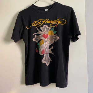 Ed Hardy Tshirt - (Lägger ut igen pga oseriös köpare) Säljer denna coola Ed Hardy t-shirt. ❤️Det är några paljetter som lossnat på korset. Se bilder. Övrigt i använt skick. Vet inte om den är äkta då jag köpte den secondhand. Storlekslapp fattas tror den är strl M/L. 💜😊