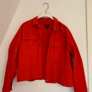 Orangeröd jeansjacka - En superfin orangeröd jeansjacka från Lindex i strl L. Använd endast ett fåtal gånger, sitter lätt oversized på mig. 