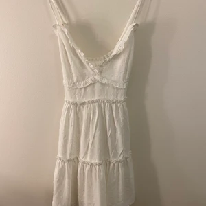  vit sommarklänning - En fin vit sommarklänning som funkar att använda både till vardags och fest. Klänningen är i storlek s men funkar också om man har xs skulle jag tro.  Klänningen är lite över knäna och har ett mönster i midjan som markerar den.