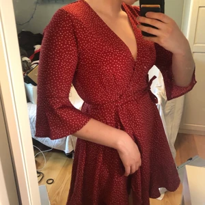 Röd omlottklänning bubbleroom  - Röd omlottklänning med vita irreguljära prickar. Otroligt flattering och somrig. Kan knytas bak eller på sidan. 