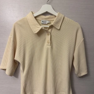 T-shirt  - En ljus gul T-shirt från na-kd som är nästintill oanvänd. Storlek xs