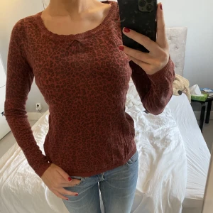 Långärmad tröja - Säljer denna röda leopard tröja med stjärnor på armbågarna och knappar på ryggen