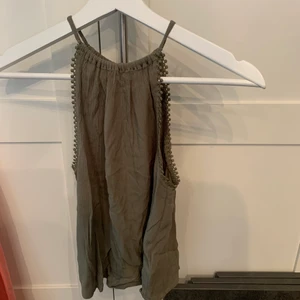 Grön topp strl XS - Grön liten topp med knapp baktill