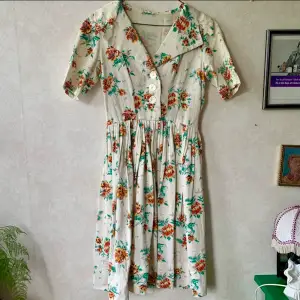 Vintage klänning med blommigt mönster och riktigt bra kvalite tyg. Den ser hemsydd ut så kan bara uppskatta storleken att vara 40
