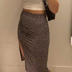 Kjol med slits - Supersöt mellanlång kjol med slits på vänsterbenet. Kjolen har resor vid midjan och slutar precis nedanför knäna på mig som är 159. Den är i storlek xs och nypris är 199 från HM. Använd cirka 3 gånger o är i superfint skick❤️