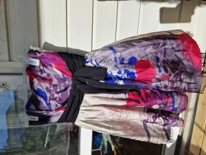 Cocktailklänning säljes  - Oanvänd grå klänning med färgade blommönster. svart band i midjan.   Axelbandslös men det finns tillhörande remmar som kan fästas.   Oanvänd med lappen kvar. Orginalpris 1249 kr Strl 38/40 Finns i Täby, kan mötas upp i Täby/centrala Stockholm.