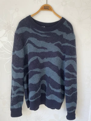 Stickad tröja från ARKET - Mörkblå stickad tröja med mönster från ARKET, använd 1 gång. Skick 10 av 10. Köptes ny för 1499 kr. Storlek L.