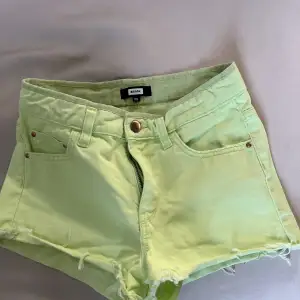 Ett par limegröna jeansshorts från BikBok, koppar färg på knappen och detaljerna vid fickorna, lite fransar vid benen, normalhög/ hög midja skulle jag nog säga.