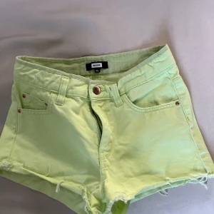 Jeansshorts  - Ett par limegröna jeansshorts från BikBok, koppar färg på knappen och detaljerna vid fickorna, lite fransar vid benen, normalhög/ hög midja skulle jag nog säga.