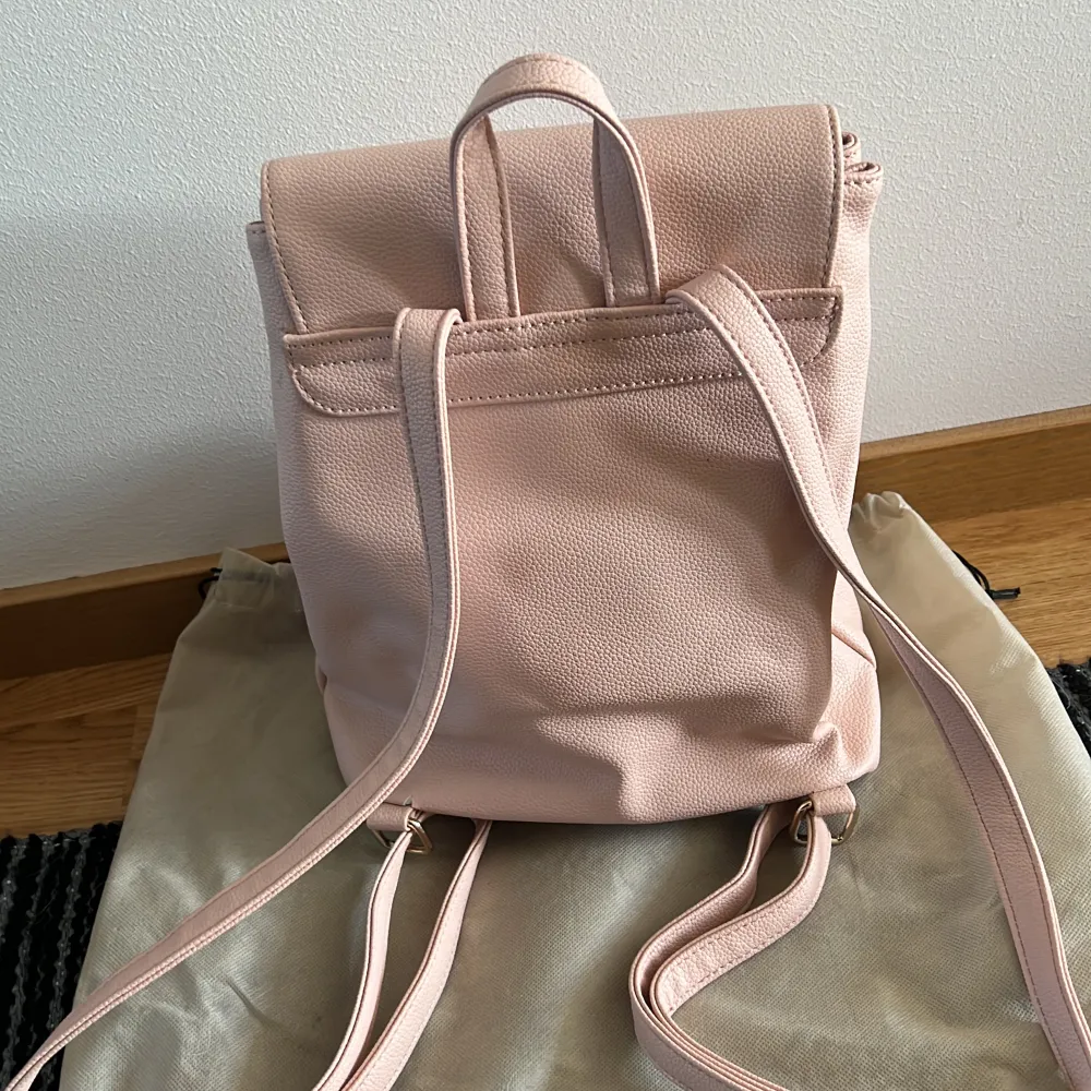 Rosa Guess ryggsäck, lite sliten baktill men går att använda om man ej har tunga saker i den. 30cm hög, 28cm bred och 12 cm djup.. Väskor.