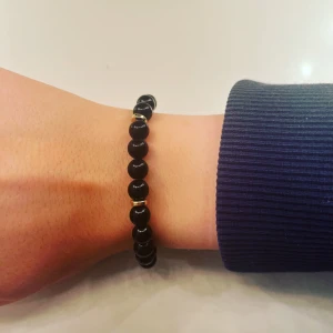 Armband  - Vi är ett Uf företag som säljer egengjorda armband, detta armband säljs där 39 kr/st+ frakt på 13 kr💕hör av dig vid intresse-Blankt svart armband med platta guld pärlor emellan💕. 