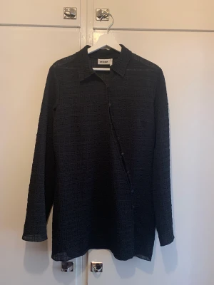 Klänning/skjorta  - Kort klänning/lång skjorta med asymmetrisk knäppning, från weekday ss22, den är figursydd vilket gör att den sitter väldigt snyggt på kroppen! 