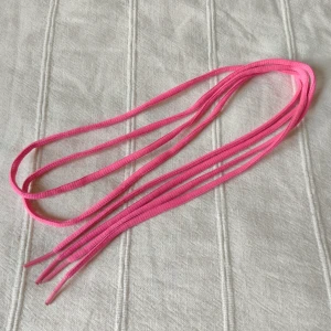 Ett par rosa/neonrosa skosnören, 110 cm - Två stycken rosa skosnören. Ca 110 cm långa. Använda under en kort period (följde med ett par Nikeskor). Kan skickas med ett frimärke (18 kr).