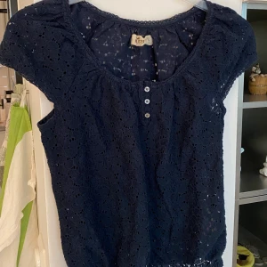 Marinblå topp - Så fin marinblå tröja i spets tyg från Hollister! Lite för stor för mig, storlek 36 (Small).