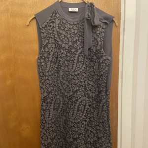 Klänning - Kortare klänning med knytdetalj på vänster sida. Dubbelt tyg så klänningen är inte genomskinlig. 