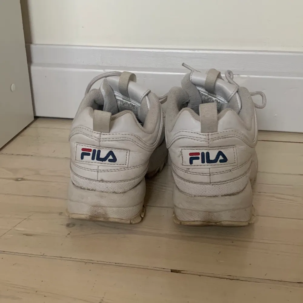 Vita sneakers från Fila i storlek 38. Skorna är använda och har lite slitningar på insidan av hälen men är i övrigt i gott skick. . Skor.