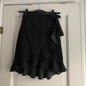 Prickig kjol - Superfin prickig kjol till sommaren!! Den går över i två delar, ena sidan med en knapp och den andra knyter man kjolen<3 tråden till knappen har tunnats ut lite