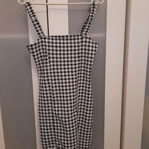 Rutig klänning - Snygg rutig klänning med slits och tajt passform men stretchig