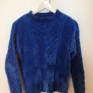 Stickad tröja - Kornblå stickad tröja i en kvalitet som liknar velour, blankt och jättemjukt. Köpt secondhand, knappt använd. 