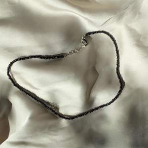 svart handgjort pärlhalsband med små pärlor
