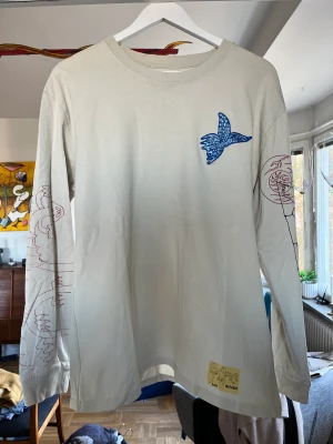 Långärmad T-shirt från Weekday - Skitfin långärmad T-shirt från Weekday med assnyggt tryck. Figuren på framsidan är broderad. Knappt några tecken på användning.