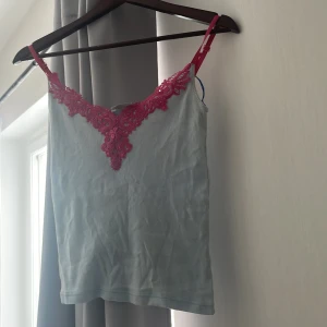 Topp - Väldigt gulligt linne med rosa spets upp till, vintage tröja med justerbara band. Aldrig kommit till andvändning, allt kan visas på om så önskas