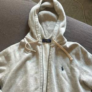 Säljer en snygg och bekväm grå hoodie från Polo Ralph Lauren. Den har en dragkedja framtill och en klassisk logga på bröstet. Perfekt för en avslappnad stil och passar till alla årstider. Den är i bra skick och redo för nya äventyr! Inga defekter vad jag kan se❤️Använd köp nu😁