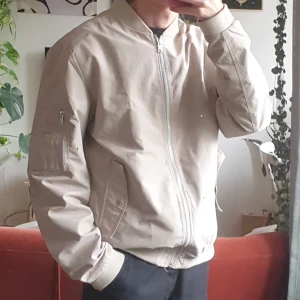 Beige bomberjacka - Beige bomberjacka Unisex M.  Tunn och vindtät. Passar till allt!  I princip oanvänd!  Lite oversize på mig som är 170/S. Skriv för mer exakta mått :)