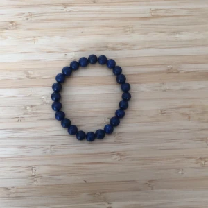 Blått pärlarmband - Säljer ett snyggt blått pärlarmband. Det är elastiskt och består av jämna, runda pärlor som ger en stilren look. Perfekt för att lägga till en färgklick till din outfit. Passar både till vardags och fest!