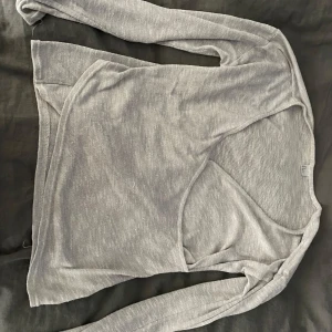 Grå långärmad tröja - Säljer en stilren grå långärmad tröja i mjukt material. Perfekt för lager-på-lager under höst och vår. Tröjan har en enkel design med normal passform och rund hals. Passar både till vardags och lite mer uppklädda tillfällen.