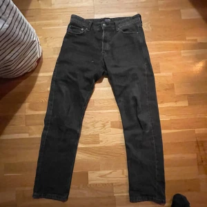 Svarta jeans från Jack & Jones - Säljer ett par svarta jeans från Jack & Jones i modellen Relaxed/Chris. De har en avslappnad passform och är perfekta för vardagsbruk. Jeansen är i bra skick och har en klassisk design med fem fickor och knappgylf.