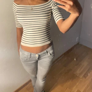 Randig offshoulder topp - Säljer en superfin randig offshoulder topp i vitt och svart. Den är croppad och har korta ärmar, Toppen är i ett stretchigt material som sitter snyggt på kroppen.  Osäker på att sälja så buda 💕