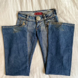 Jeans med snygga fickor - Köpta på Vinted. Är insydda på sidorna, går att sprätta upp, blir då ungefär 4 cm bredare runt midjan.  Midja tvärs över: 35 cm.  Midja hela vägen runt: 70 cm.  Innerbenslängd: 82 cm.  Lågmidjade: 18 cm från knappen ner. 