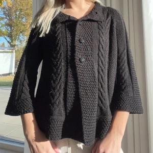 Svart stickad kofta med knappar - Säljer en mysig svart stickad kofta med flätmönster och trekvartsärmar. Den har en klassisk krage och knappar framtill. Perfekt för höst och vinter när du vill hålla dig varm och stilren. Passar både till vardags och lite finare tillfällen. 🖤