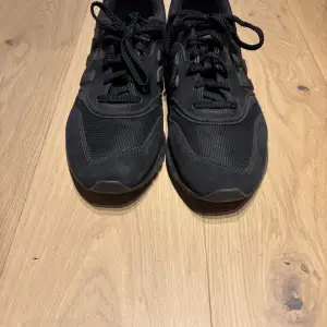 Säljer ett par svarta New Balance sneakers i oanvänt skick. De har en klassisk design med snörning och är perfekta för vardagsbruk. Skorna är bekväma och har en stabil sula, vilket gör dem idealiska för både promenader och lättare träning. Skriv för mer bilder!