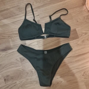 Grön bikini - En fin bikini i grönt ribbat tyg. Den har justerbara axelband och stängning på ryggen.