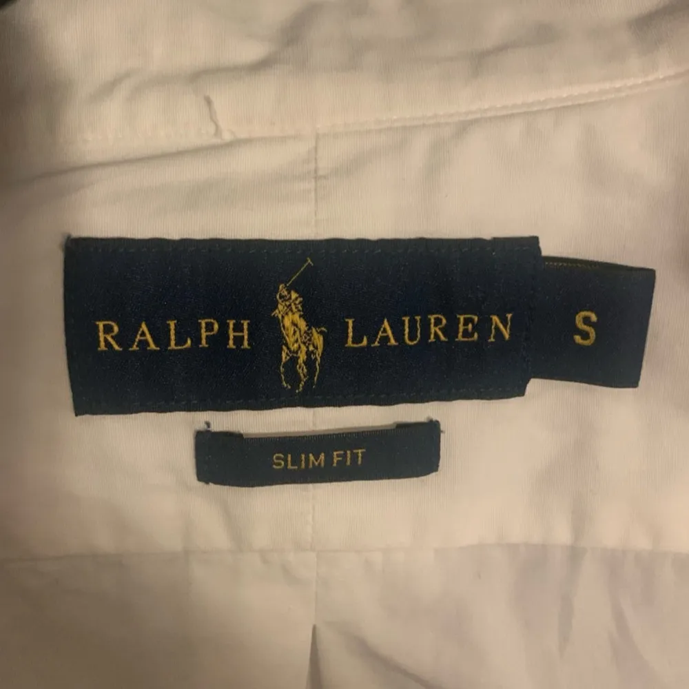 Ralph Lauren skjorta som är helt ny och endast använts vid ett tillfälle på en skolavslutning.   Marinblå Ralph Lauren logga på bröstet.   Skjortan är i storlek S med en slim fit passform.   Samma dag leverans ✅. Skjortor.