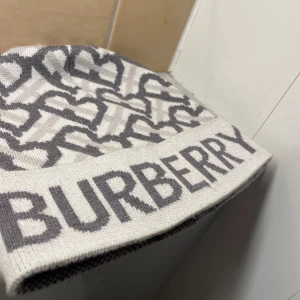 Vit burberry mössa - En stilren burberry mössa med en touch vit och grå färg, mössan är i bra skick och nästan aldrig använd. Priset går att diskutera. 