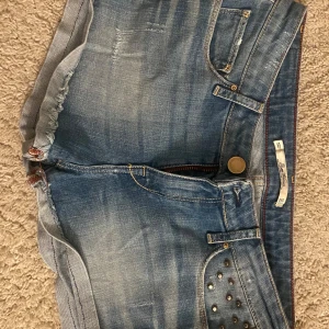 Blå jeansshorts med nitar - Snygga blå jeansshorts från Zara med coola nitar på fickan. De har en klassisk femficksdesign och en bekväm passform. Perfekta för sommardagar eller festivaler! 🕶️