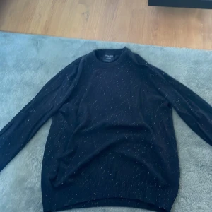 Mörkblå tröja från Grand Frank - Säljer en snygg mörkblå tröja från Grand Frank med färgglada prickar. Den är i storlek medium och gjord av 94% bomull, 3% kashmir och 3% ull. Perfekt för både höst och vinter. Tröjan har långa ärmar och en normal passform. Supermysig och stilren! Pris kan diskuter skriv till mig över minsta fundering